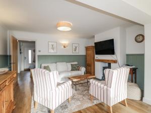 ein Wohnzimmer mit einer Couch und zwei Sesseln in der Unterkunft Parkfields Cottage in Uttoxeter