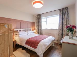 ein Schlafzimmer mit einem großen Bett und einem Fenster in der Unterkunft Parkfields Cottage in Uttoxeter
