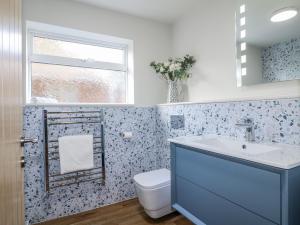 ein Badezimmer mit Toilette, Waschbecken und Fenster in der Unterkunft Parkfields Cottage in Uttoxeter + 21 Fotos