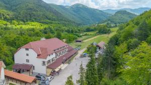 an aerial view of a building with mountains in the background at Pensiunea Popasul Ursilor Medve Barlang Peștera Urșilor in Chişcău