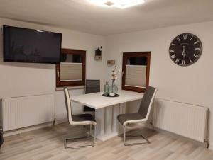 a dining room with a table and a clock on the wall at Haus Heimat & Appartement in Huben