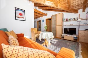a living room with an orange couch and a table at Ferienwohnung Gästehaus Büchele Kleinwalsertal in Hirschegg