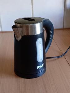 a black coffee pot sitting on a wooden floor at TINY HOUSE Los Angeles in Los Ángeles