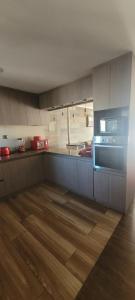 a kitchen with wooden floors and a stove top oven at Depto 3 in Villarrica