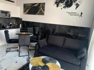 a living room with a couch and a table at Apartments by Radecka Zarembowicza Wrocław Lotnisko - Nowoczesny apartament o podwyższonym standardzie in Wrocław