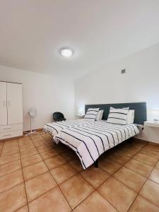 a large bedroom with a large bed in a room at Casa Pão - 5 mins from Machico centre with private parking in Machico