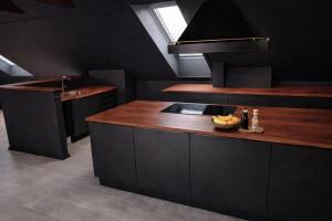 a kitchen with black cabinets and a wooden counter top at FourSeasons - Carnival Summer Lounge in Aalborg