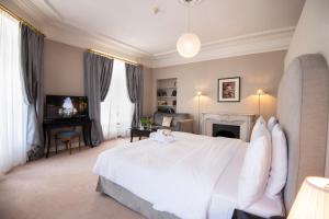a bedroom with a white bed and a fireplace at La Résidence des Trois Couronnes in Vevey +57 photos