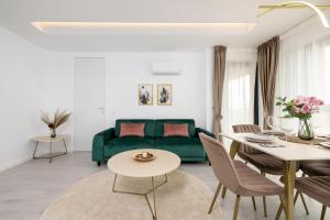 a living room with a green couch and a table at Lila Residence - by Solinis Homes in Bucharest