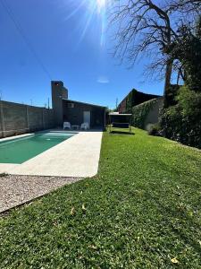 a yard with a swimming pool and a grassy field at La quinta de Vito in San Pedro