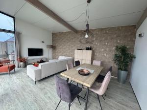 a living room with a table and a couch at Beach Lodge in Callantsoog
