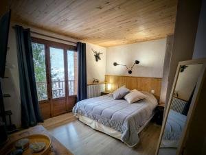 a bedroom with a bed and a large window at Auberge Saint Antoine in Pelvoux