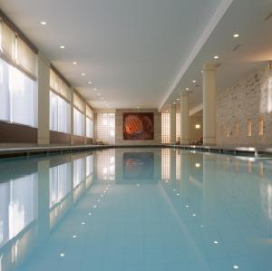 a large swimming pool in a building with a swimming pool at La Résidence des Trois Couronnes in Vevey