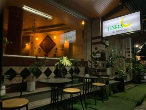 a restaurant with tables and stools in front of a store at Linda rooms in Chanthaburi