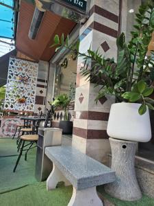 a bench sitting in front of a building with plants at Linda rooms in Chanthaburi