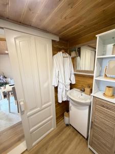 a bathroom with a white door and a sink at Tiny House Beija-Flor in Challex