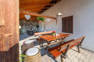 a patio with a wooden table and two benches at Beim Sarner in Caldaro