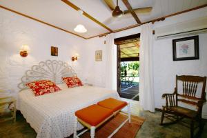 a bedroom with a bed and a chair and a window at La Cocoteraie in Le Morne +44 photos