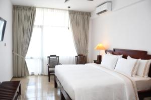 a hotel room with a large bed and a window at Hotel Lanka Super Corals in Hikkaduwa