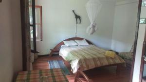 a bedroom with a bed and a table in a room at propriete in Antsirabe
