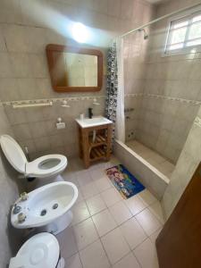a bathroom with a toilet and a sink and a shower at Duplex 4 con cochera privada y parrilla in San Clemente del Tuyú