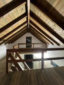 a loft with wooden ceilings and a wooden floor at Casinha do Rosa in Imbituba