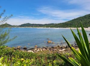 a beach with a bunch of rocks in the water at Casinha do Rosa in Imbituba