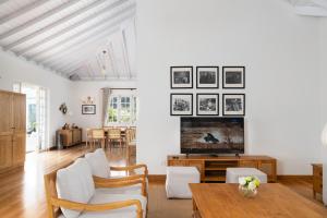 a living room with a tv and a table at Aadya Tea Bungalows by Aahaasa in Hatton