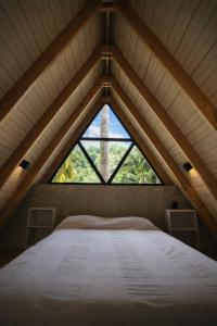 a bed in a room with a large window at Casa Cayena - Hibiscus House in El Valle
