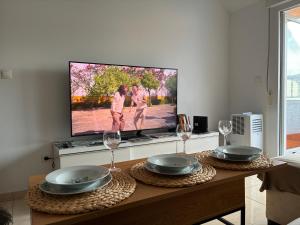 a living room with a table with two glasses and a tv at Atico Cortegada in Boiro