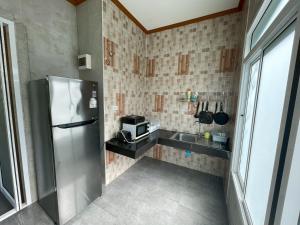 a small kitchen with a refrigerator and a sink at Koh Chang Hill-View Hideaway in Trat