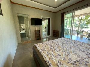a bedroom with a bed and a large window at Koh Chang Hill-View Hideaway in Trat