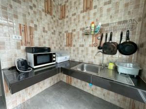 a small kitchen with a sink and a microwave at Koh Chang Hill-View Hideaway in Trat