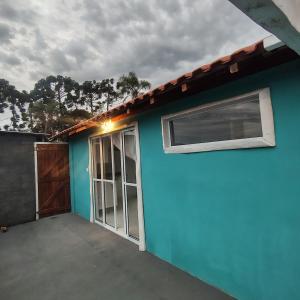 a blue house with a window and a door at Chácara Sitara - Chalé Safira in Caldas