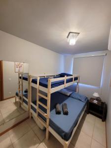 two bunk beds in a room with shoes on them at Ap Clube Piçarras in Piçarras +62 photos
