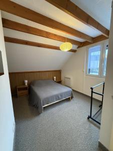 a bedroom with a bed and a large window at 2 chambres avec mezzanine in Le Lioran