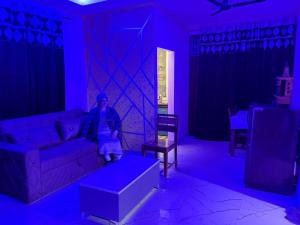 a person sitting on a couch in a blue room at Good Vibes Retreat in Birbhaddar +4 photos