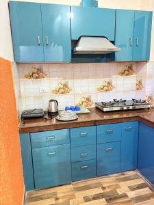 a kitchen with blue cabinets and a counter top at Good Vibes Retreat in Birbhaddar