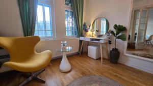 a room with a chair and a table and a mirror at Apartament Centrul Vechi in Târgovişte