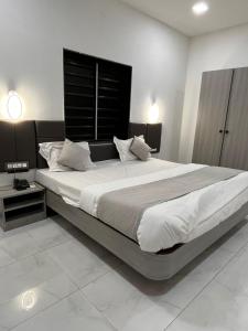 a bedroom with a large bed with white sheets and pillows at hotel rajwada in Bhuj