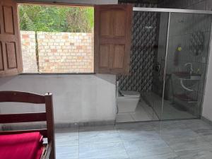 a bathroom with a toilet and a glass shower at Casa na Floresta in Santarém