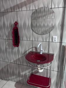 a bathroom with a red sink on a wall at Casa na Floresta in Santarém