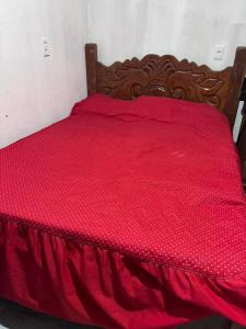 a red bed with a red comforter on it at Casa na Floresta in Santarém