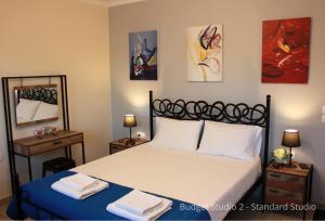 a bedroom with a bed and some paintings on the wall at Budget Studios Haraki in Haraki