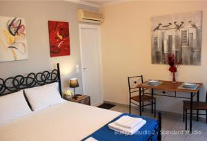 a bedroom with a bed and a table with a table at Budget Studios Haraki in Haraki +29 photos
