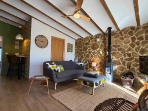 a living room with a couch and a stone wall at Casa de Olivos - Unique Apartments - Adult Only in Traiguera