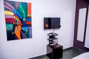 a room with a tv on a wall with a camera at The Close in Asaba +23 photos