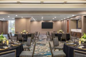 a conference room with tables and chairs and a screen at Hotel Indigo Columbus Architectural Center by IHG in Columbus
