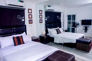 a bedroom with two beds and a mirror at The Close in Asaba