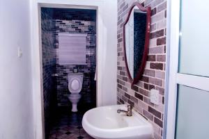 a bathroom with a sink and a toilet at The Close in Asaba